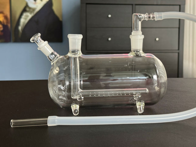 XL Super Sub Pipe Side View – A clear glass, horizontally oriented water pipe with a sleek design and stable four-footed base.