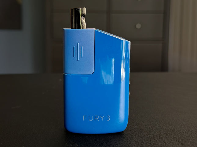 Blue Fury 3 vaporizer standing on a wooden surface, highlighting the smooth texture and discreet form factor.