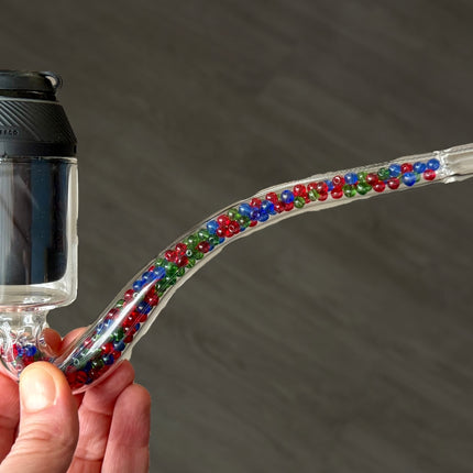 Hand holding the Puffco Proxy J-Hook with the Proxy installed, showing size and bead-filled cooling.